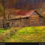 Weathered barn set against a mountainside painted in rich fall colors.